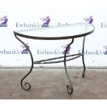 20th century demi lune glass topped and iron framed console table with scrolling details. 101W x 52D