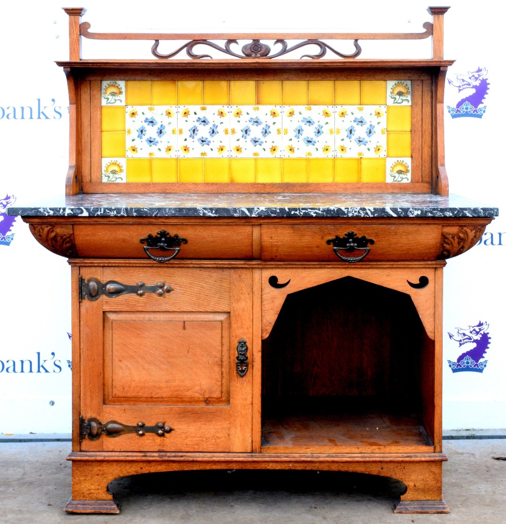 Art Nouveau oak washstand, the carved gallery with foliate decoration above a yellow tiled back,