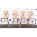 Set of four pine wheelback dining chairs.