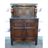 Oak court cupboard, with single door flanked by baluster supports above two cupboard doors