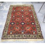 Pink ground carpet with repeating floral design within floral border, 209 x 137cm