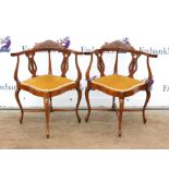 Pair of corner chairs with carved floral top rails on cabriole legs united by X-stretchers