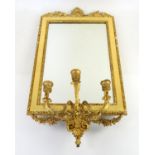 Gilt wood girandole with rectangular bevelled glass plate above three sconces with scrolling