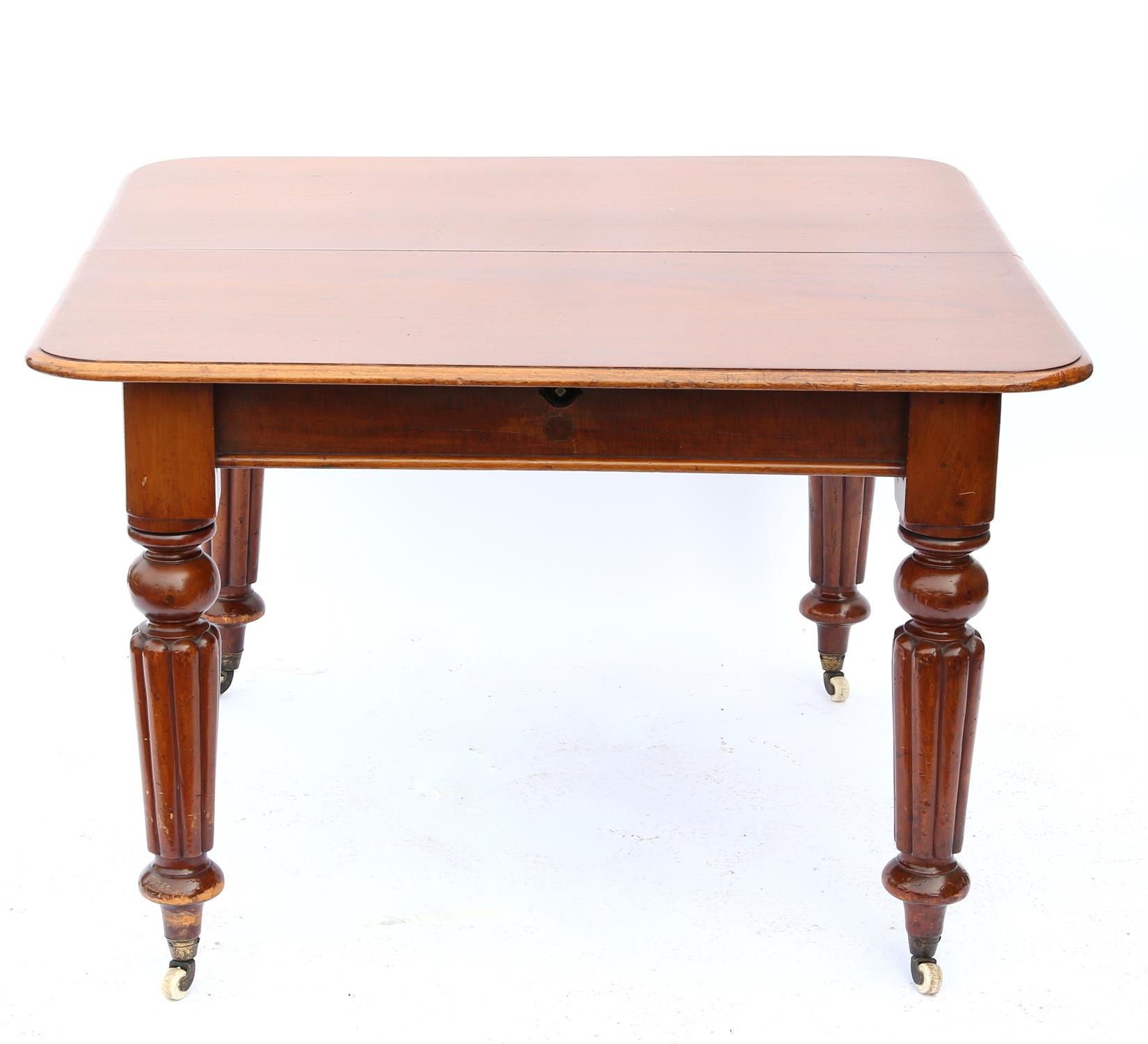 19th century mahogany extending dining table with three extra leaves, on reeded legs and castors,