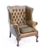 Early 20th century mahogany wingback armchair, with studded button back leather upholstery on ball