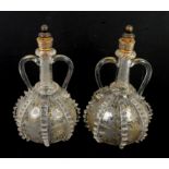 Pair of glass shaft and globe decanters with applied pinched trails and twin handles,