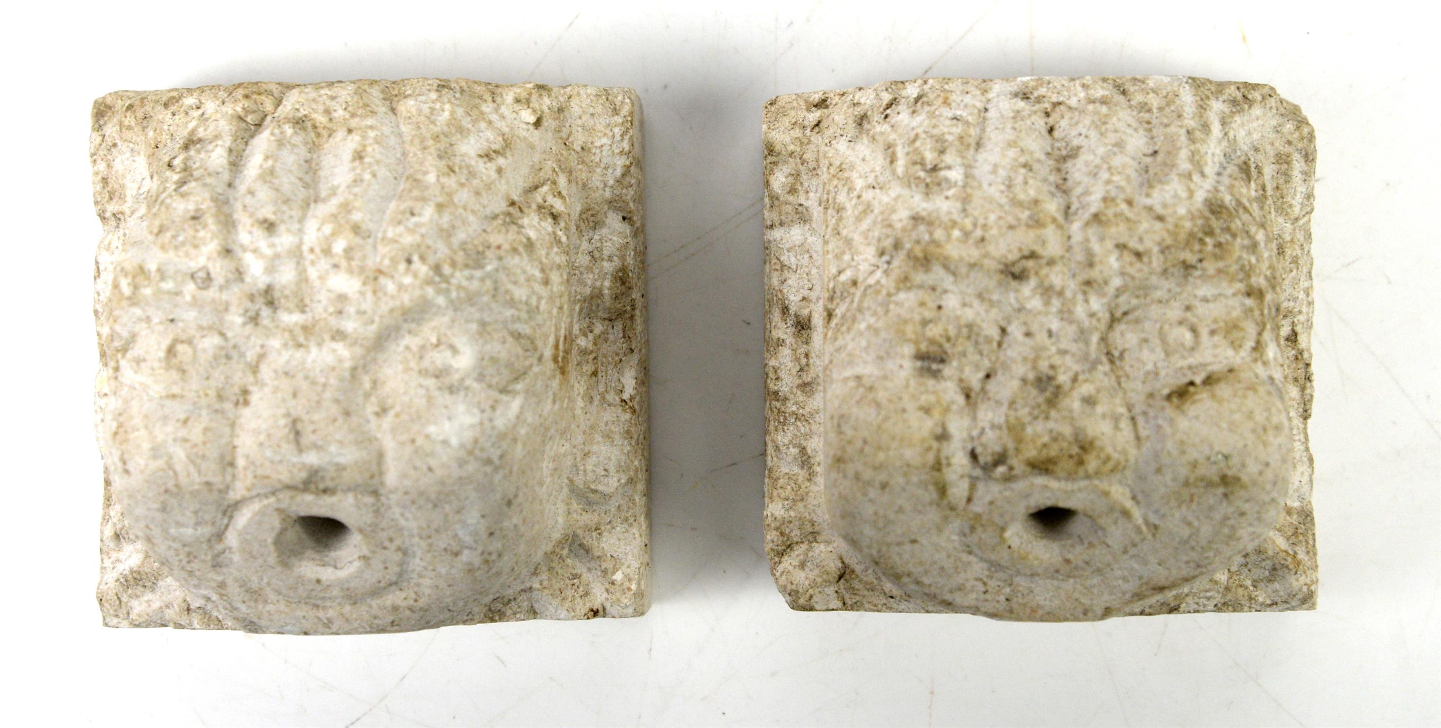 Pair of carved stone mask water spouts, h9.5cm x w10cm x d7.5cm,