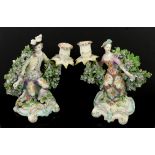 Pair of 18th century Derby porcelain bocage figural candlesticks of male and female figures,