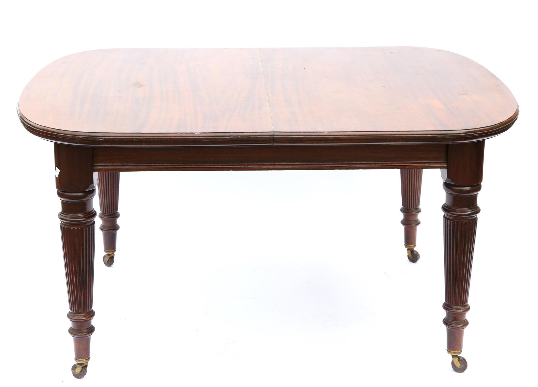 Late 19th century mahogany extending dining table, with reeded tapering legs on castors,