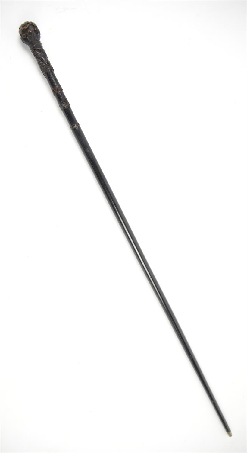 Early 20th century swordstick with carved ebonised handle in tubular black metal sheath, 94cm long,