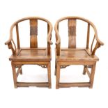 Pair of Chinese elm oxbow back armchairs, the splat with carved foliate decoration,