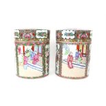 Pair of 20th century famille rose cylindrical jars and covers, decorated with panels of figures,