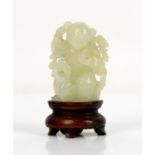 A small Chinese green jade figure of a boy standing beside a duck; about 5 cm high; with a wood