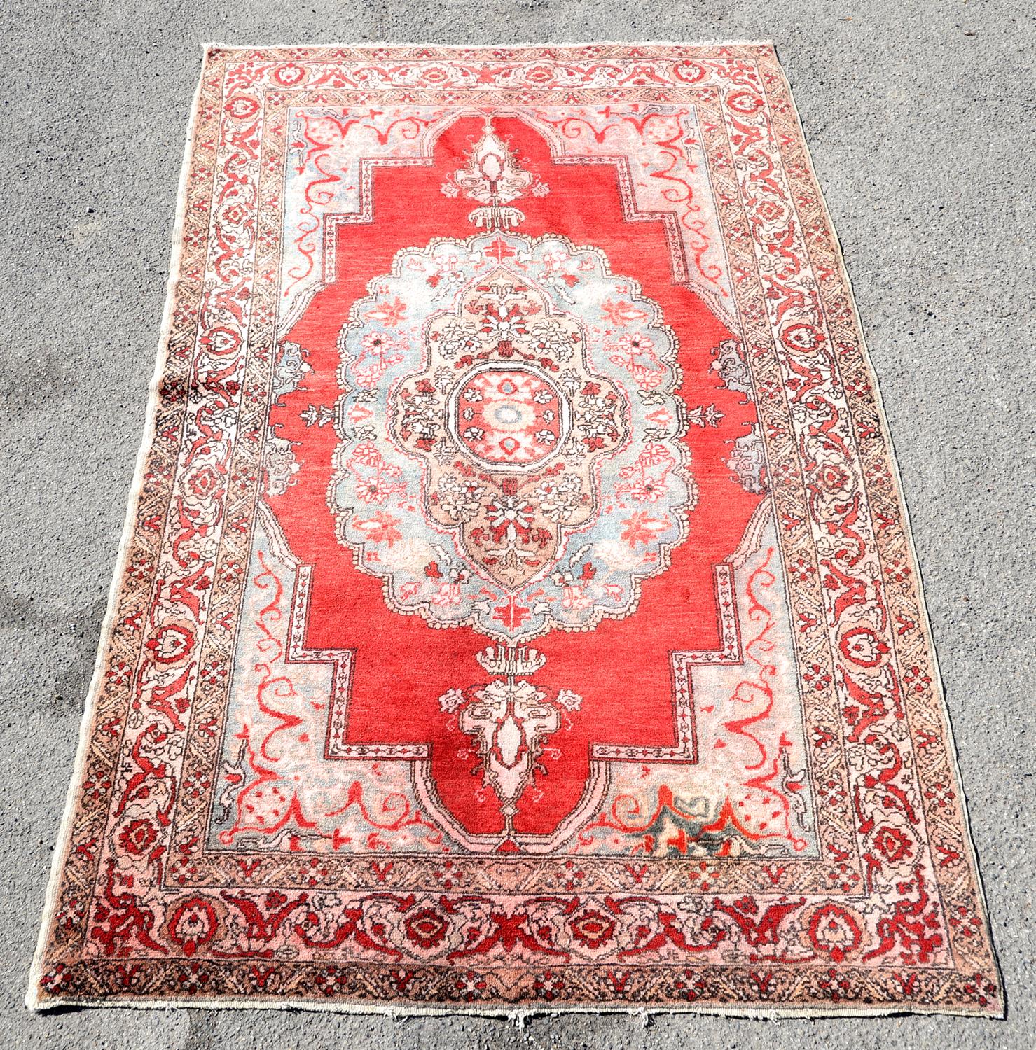 Vintage Iranian rug with central medallion on a red ground within a floral border, 247 x 153cm