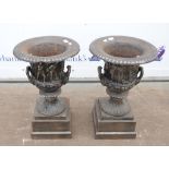 Pair of cast metal urns, relief decorated with Classical figures, on stepped square base,