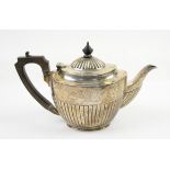 A silver teapot of oval form with fluted lower body, wooden handle Birmingham 1904, 15 oz