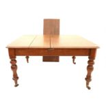 Oak extending dining table with one extra leaf, on turned legs and castors (one castor detached but