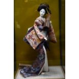 Large Japanese Geisha doll, wearing coral and blue kimono and holding a parasol, in glass case h63.