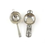 Two silver tea strainers, one with a pierced floral stem handle, the other London 1937