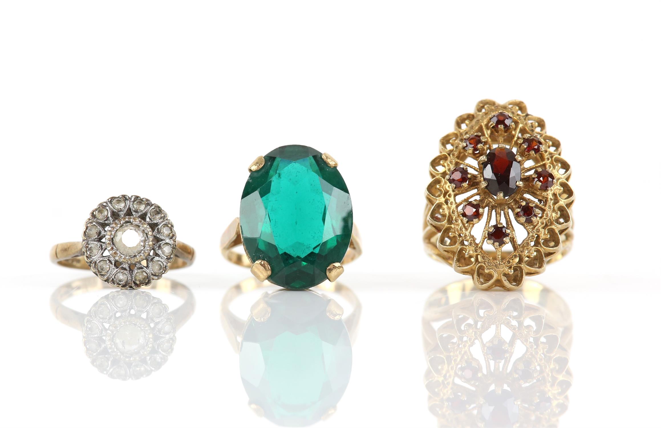 Three rings, including a garnet cluster ring, size Q, a green paste single stone ring,