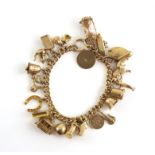 Gold curb link bracelet, large bolt ring clasp, with twenty-one vintage charms attached,