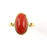 Coral dress ring, oval cabochon cut coral 13 x 7mm, set in a rub over setting, stamped 18 ct,