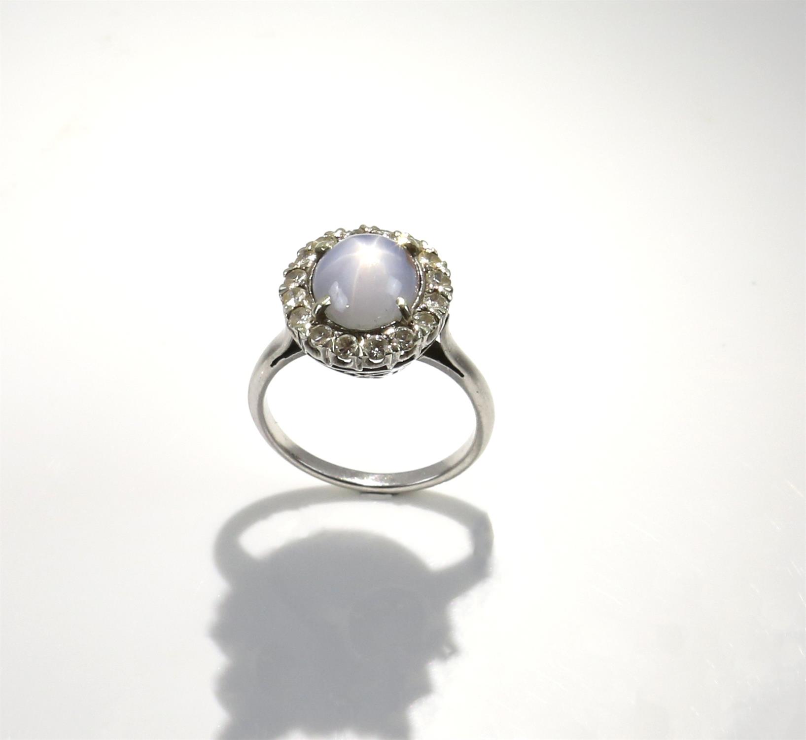 Star sapphire and diamond cluster ring, central oval cabochon cut sapphire, estimated weight 6.