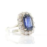 Sapphire and diamond cluster ring, with an emerald cut sapphire weighing an estimated 4.16 carats,