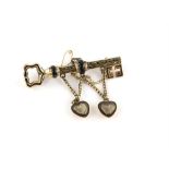 Victorian key brooch, with black enamel floral detailing, two suspended heart lockets containing