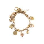 Fancy link charm bracelet and ten charms, including a horseshoe, binoculars, bell,