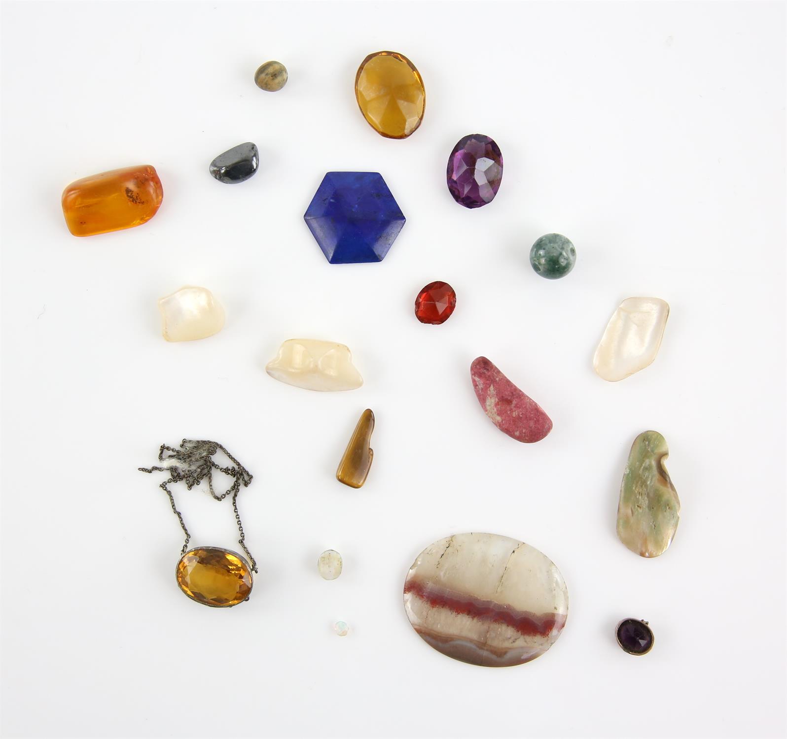 A group of mainly loose semi precious gemstones, including hematite, a moss agate bead, amber,