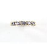 Tanzanite and diamond half hoop ring, set with five round cut tanzanites, spaced with single cut
