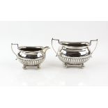 Victorian silver cream jug and sugar bowl, with half gadrooned bodies and on ball feet, by Martin,
