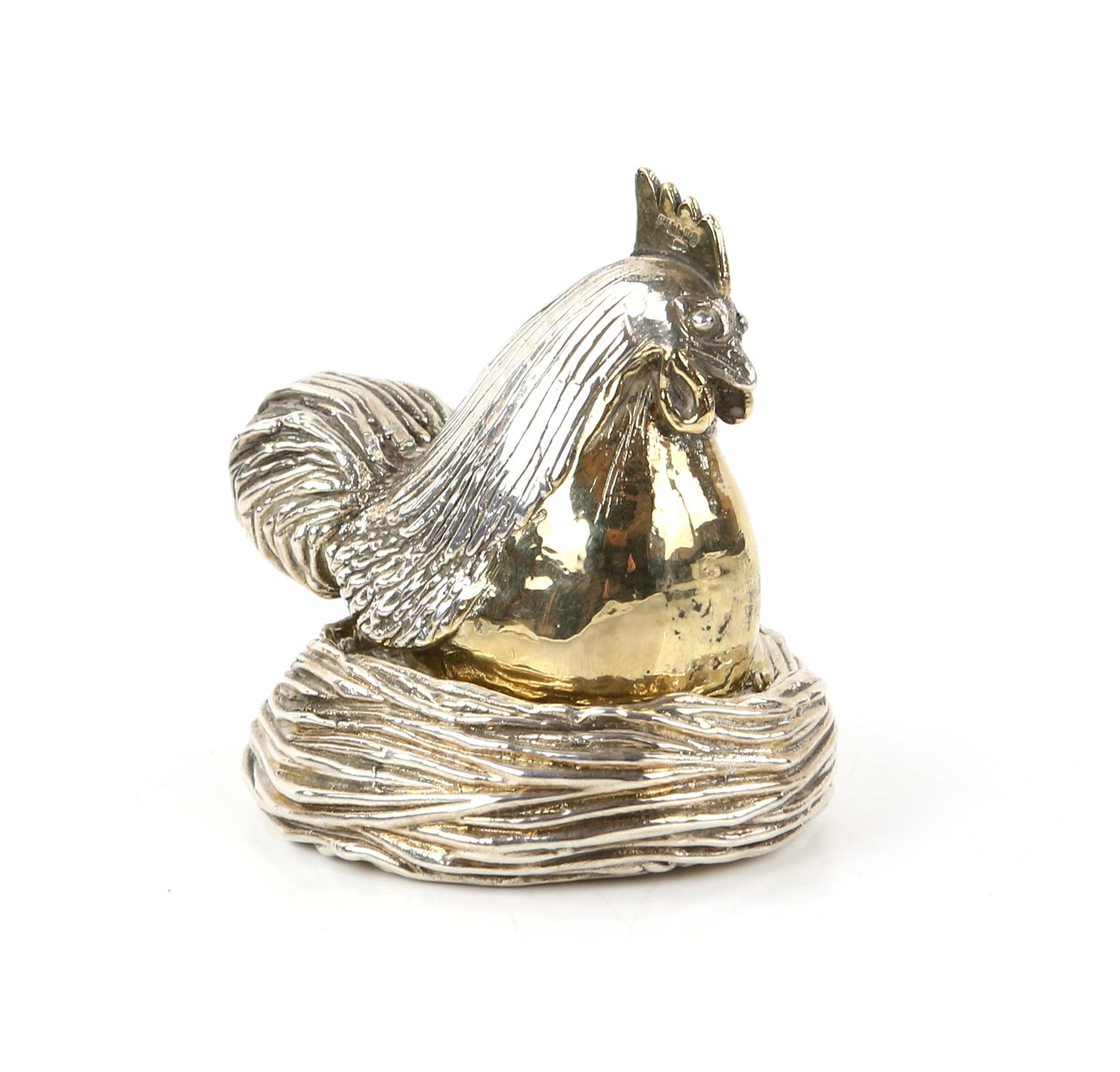 Three piece model of a filled silver chicken with gilt decoration on an egg within a nest by A Ltd,