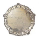 George V silver presentation salver with shaped shell and scroll border, engraved with facsimile