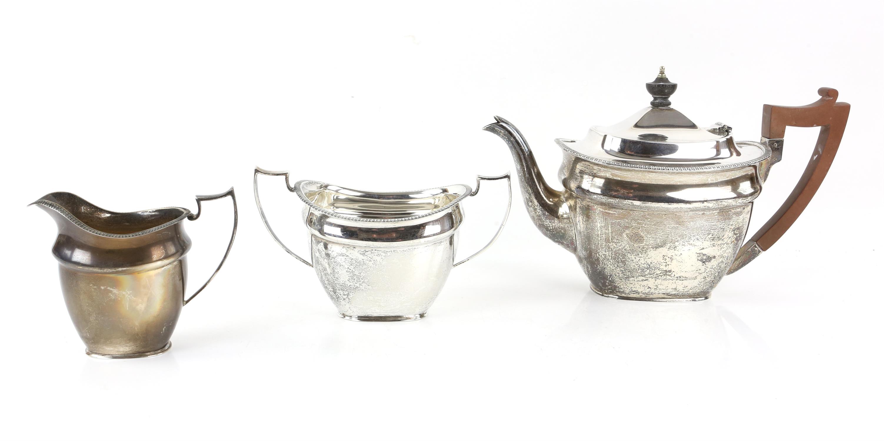 George V silver three piece tea service with gadrooned rims, comprising teapot, cream jug and sugar