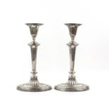 Pair of George V silver candlesticks with stylised floral decoration on elliptical bases,