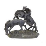 Large cast metal sculpture of a mounted cowboy about to lasso a horse, on naturalistic base,