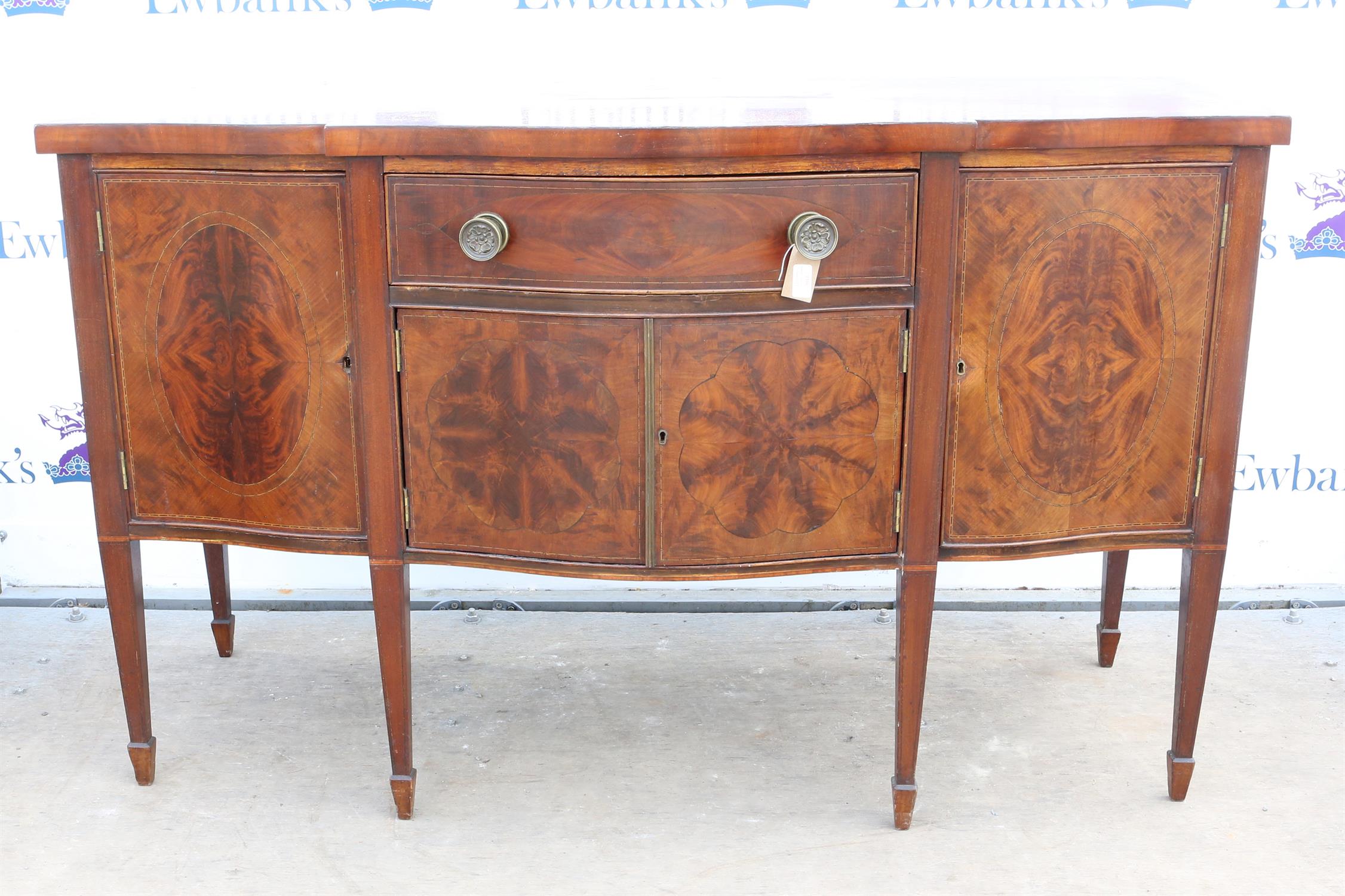 Late 19th century mahogany serpentine sideboard, with a central drawer over a cupboard flanked by