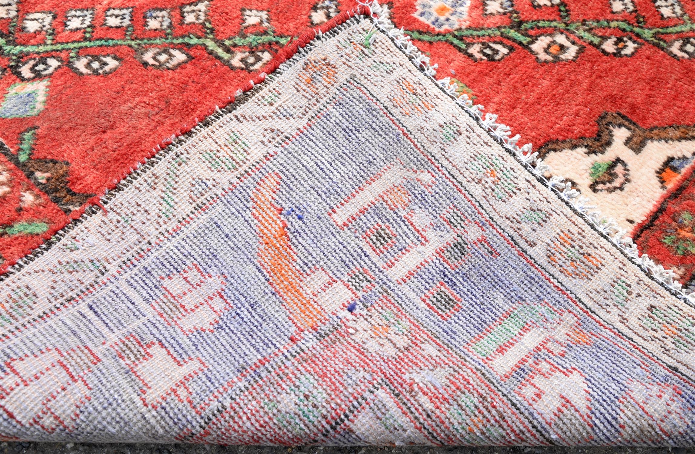 Persian Shiraz village carpet, with twin floral medallions on red ground with vine leaf and floral - Image 2 of 2