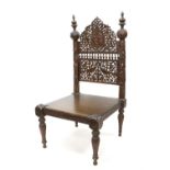 20th century Indian carved hardwood low chair with a panel depicting Ganesha on foliage carved