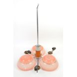 Art Deco three branch chrome ceiling light with three blush pink glass shades, caramel bakelite