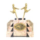 Art Deco clock mounted with a pair of gilt female figures holding a hoop, on stepped pink with