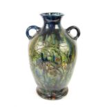 Large Burmantofts style twin handled glazed vase, decorated with fruit trees, 60cm high