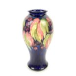 Moorcroft vase of inverted baluster form decorated in the Leaf and Berry pattern on a dark blue
