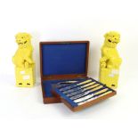 Cased set of fish knives and forks together with a pair of yellow glazed Dogs of Fo.