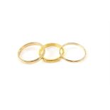 Three gold wedding bands, including a 2.5mm band, ring size N, stamped 22 ct, with a 2mm court ring