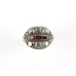 Antique ring, centrally set with three rubies, surrounded by an oval motif of old cut diamonds,