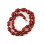 Bakelite graduated oval bead necklace, strung with knots, with a gold plated bolt ring clasp,