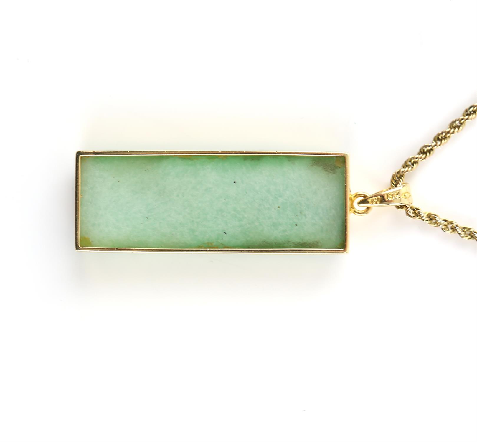 A green glass pendant depicting wheel detailing, in a mount stamped 18 ct, measuring 5 x 2 cm, - Image 2 of 2